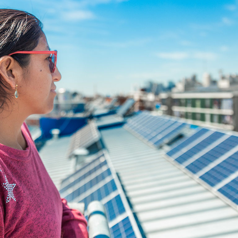 Mujer observa los paneles solares instalados en su barrio en Buenos Aires