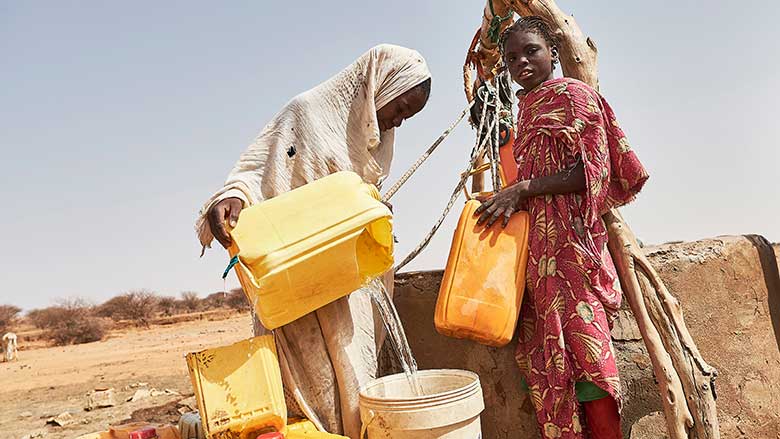 Dos mujeres sacando agua de un pozo 