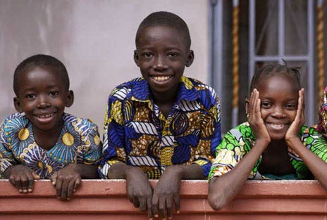 Three children smiling and looking at the camera
