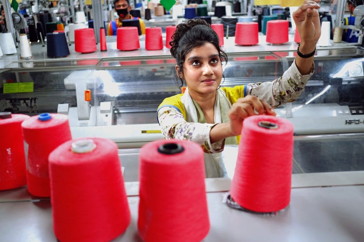 A woman works at a sewing machine in a factory.