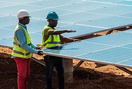 Two men working among solar panels